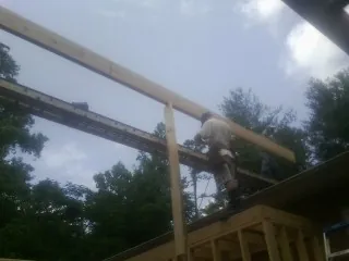 Carpenter setting a ridge beam over a new addition frame — Ice Dam Removal by Roofing Brothers in Clarington