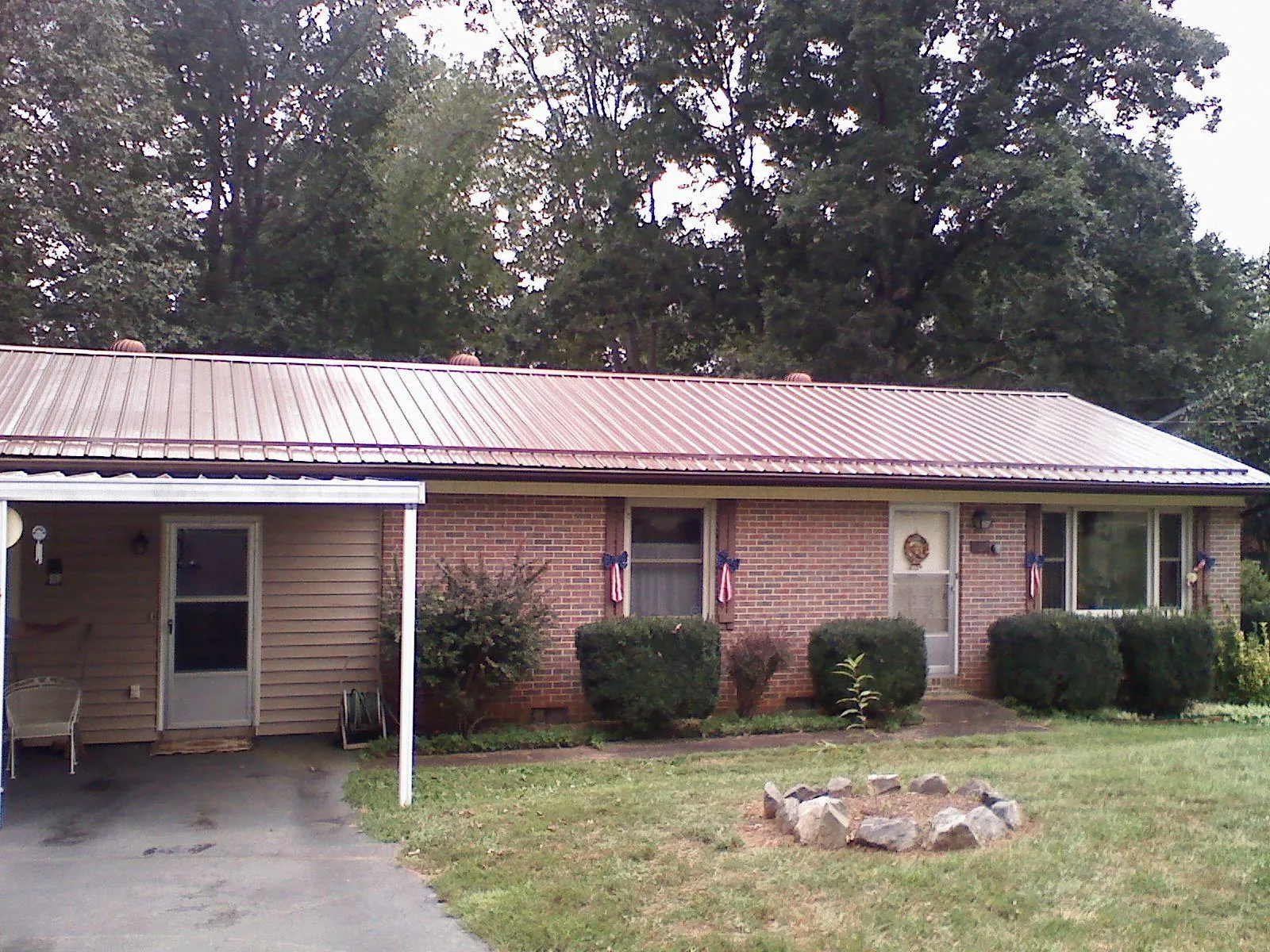 Bronze metal roof and carport on a brick ranch home — Roof Repair work by our crew in Clarington