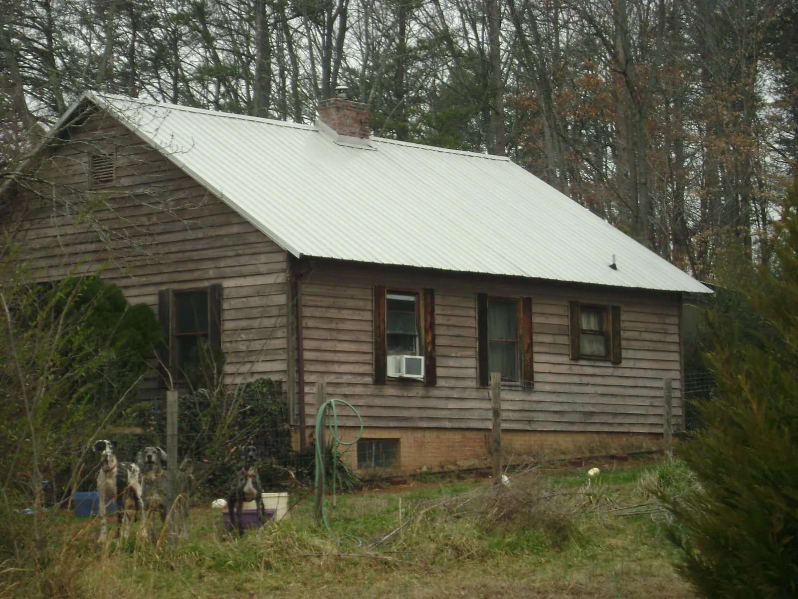 White metal roof on an old wood sided farmhouse, from a Metal Roof Installation job in Clarington
